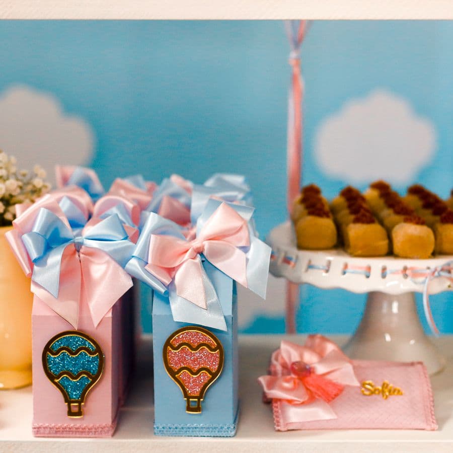 Pastel gift boxes with pink and blue bows on a baby shower table