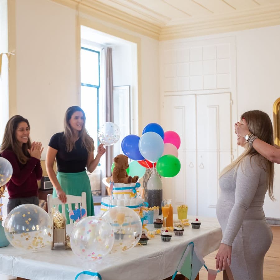 Pregnant guest reacting joyfully to a decorated shower table
