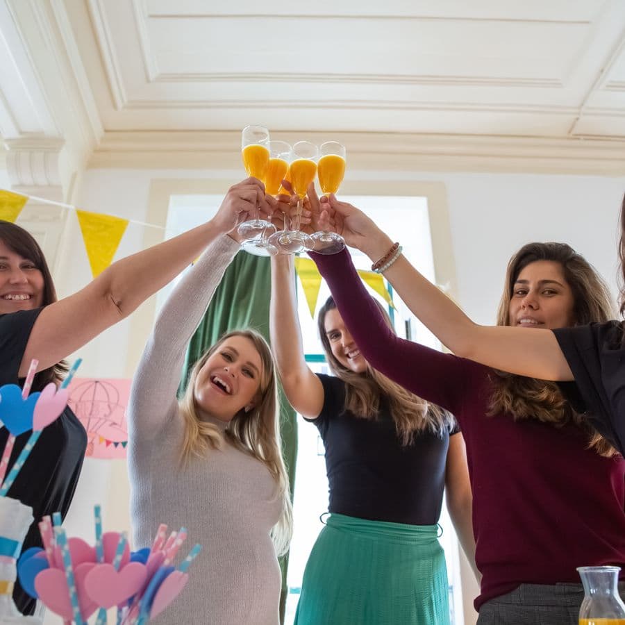 Women raising glasses for a toast at the baby shower