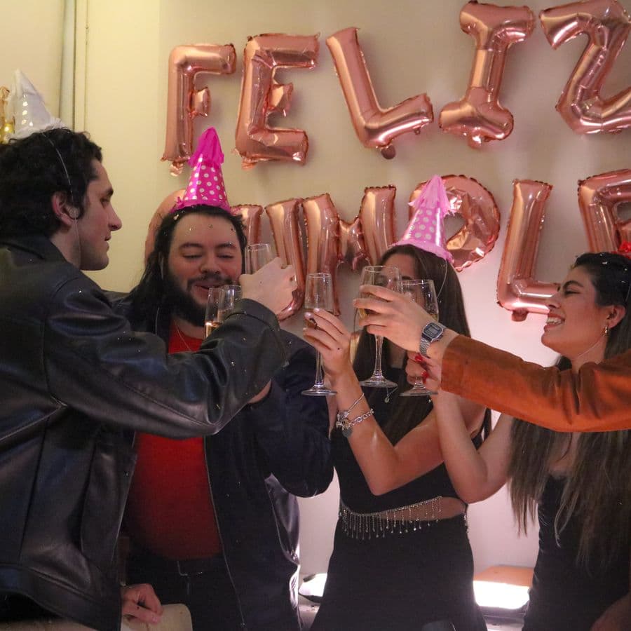 Friends clinking champagne glasses in party hats