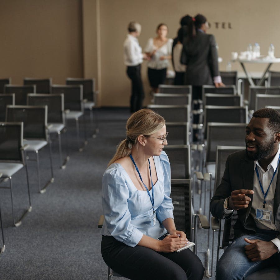 Two attendees having a seated conversation during a break