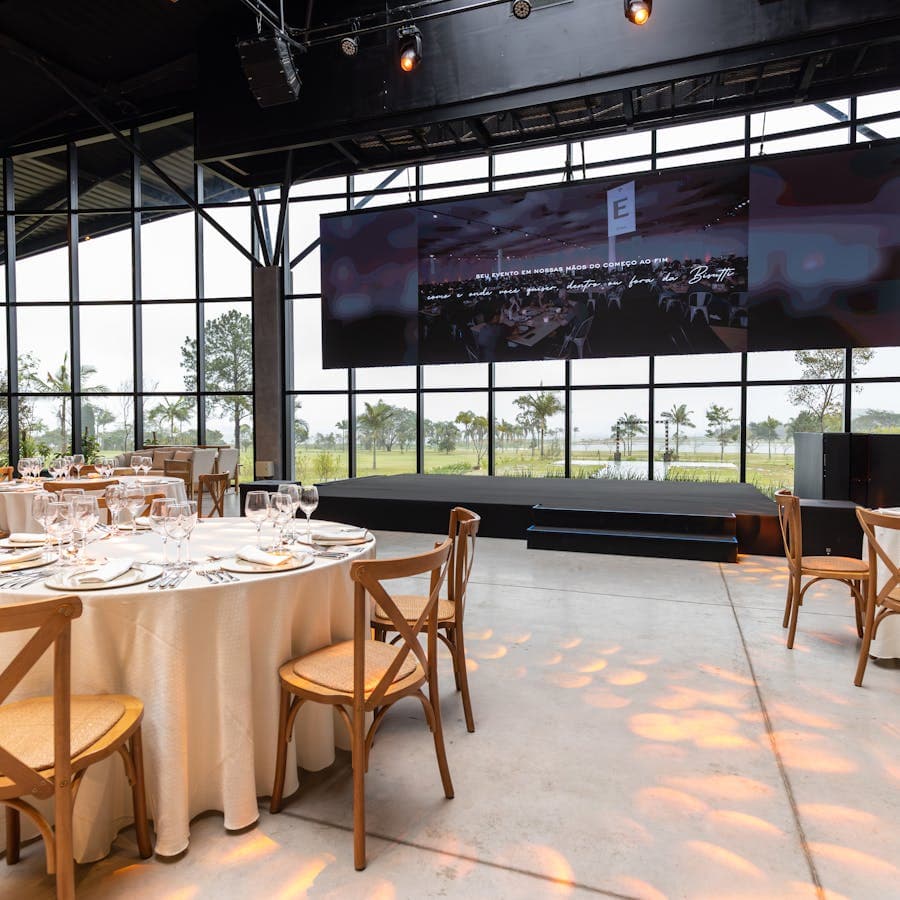 Elegant event venue with set tables and a large presentation screen