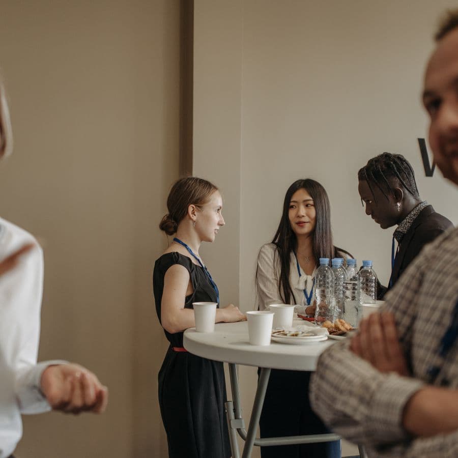 Attendees networking around a cocktail table with refreshments