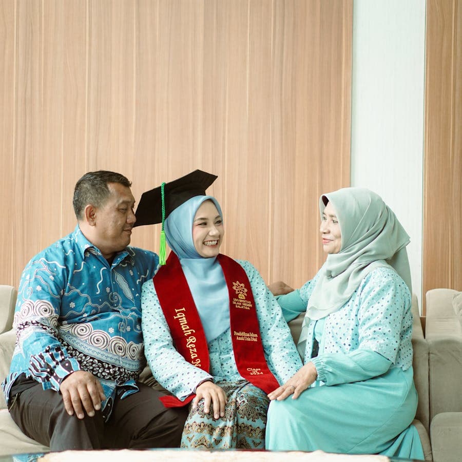 Proud parents seated beside their smiling graduate daughter