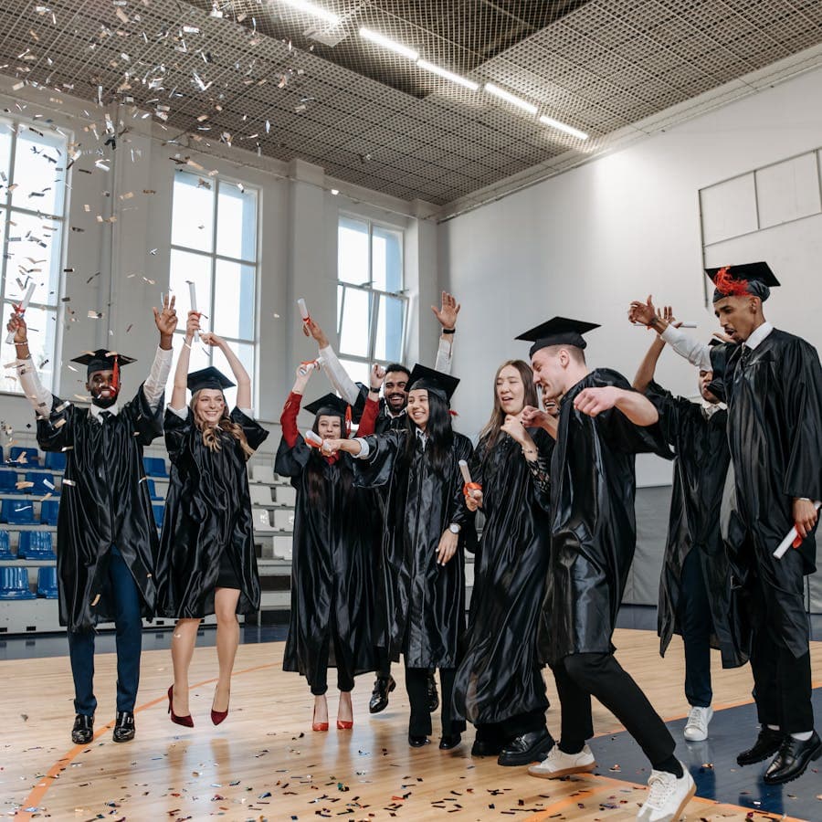 Graduates celebrating with confetti in a gymnasium