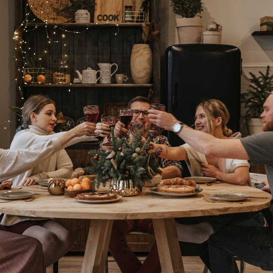 Friends toasting around a festive holiday dinner table