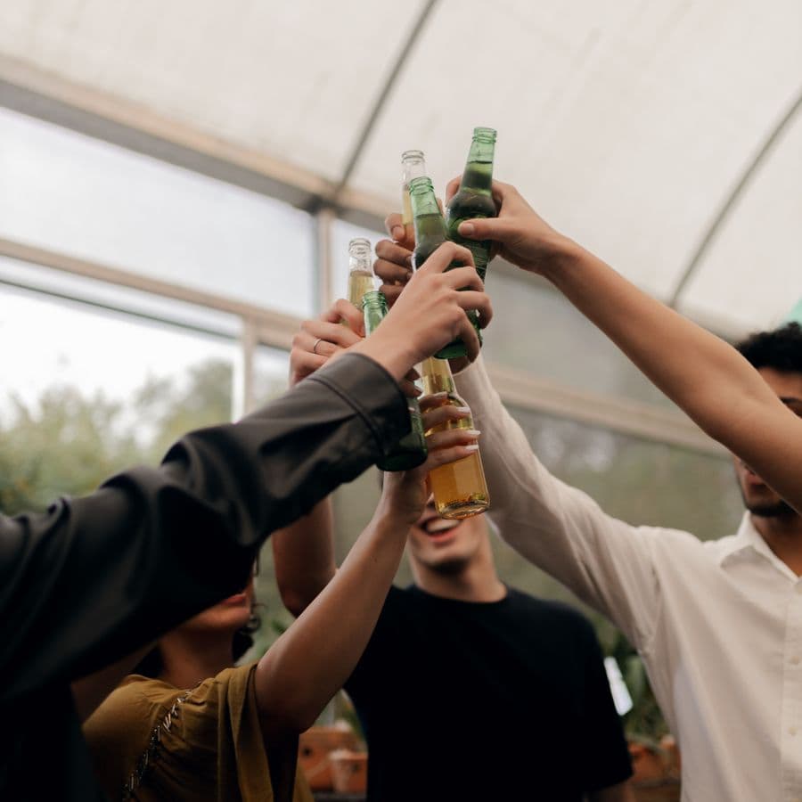 Friends raising bottles in a toast at a party