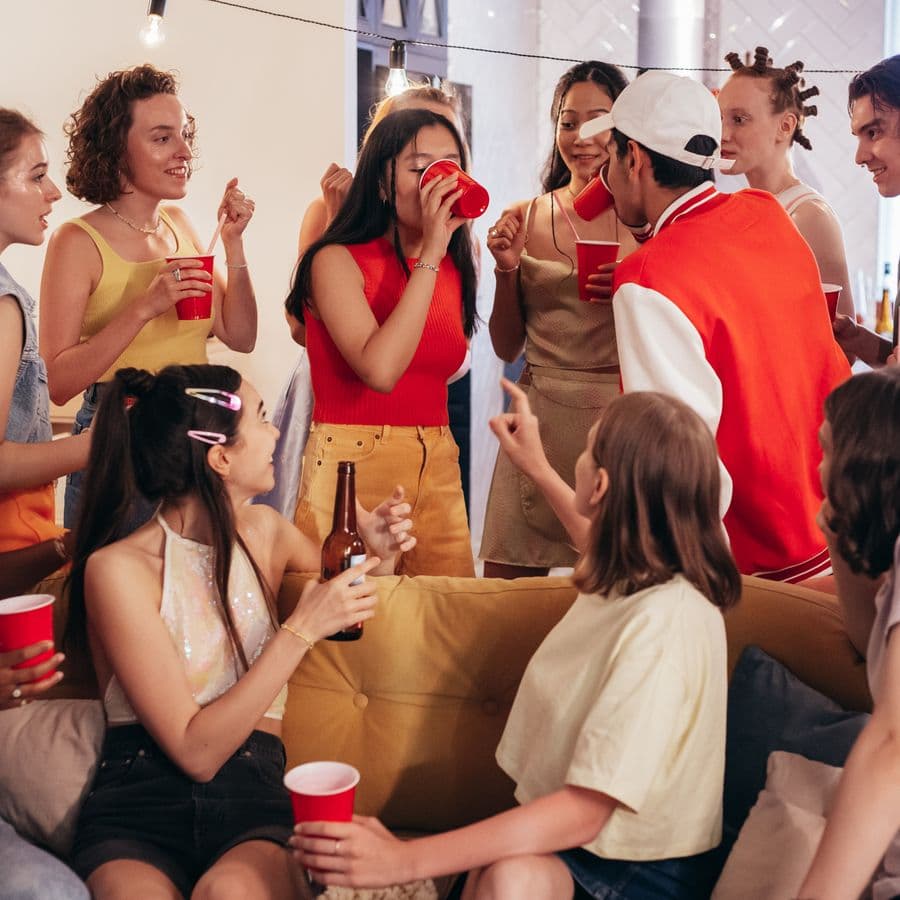 Lively group of friends with cups at a house party