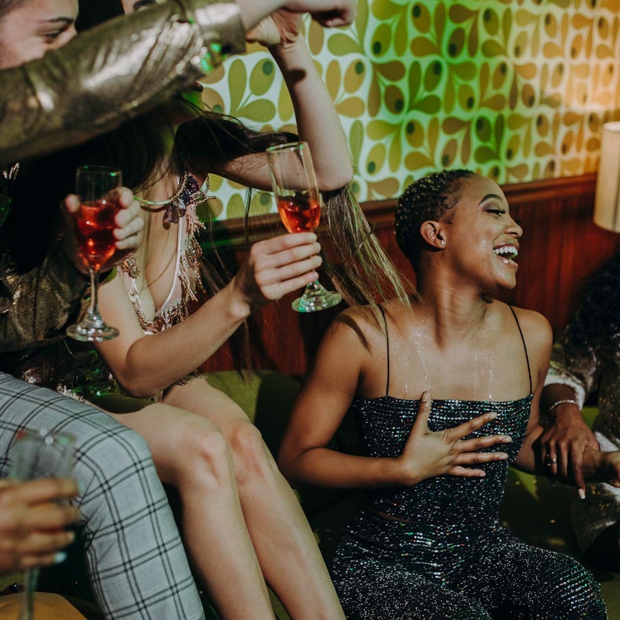 Friends laughing with champagne glasses at a lively party