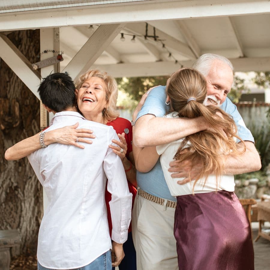 Grandparents embracing their adult children at the reunion
