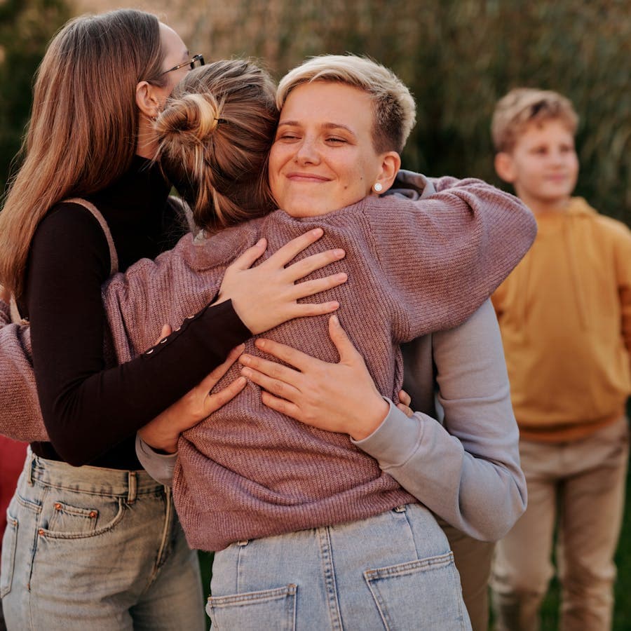 Family members sharing a warm group hug outdoors