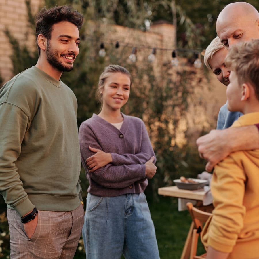 Family standing in a circle chatting in the backyard