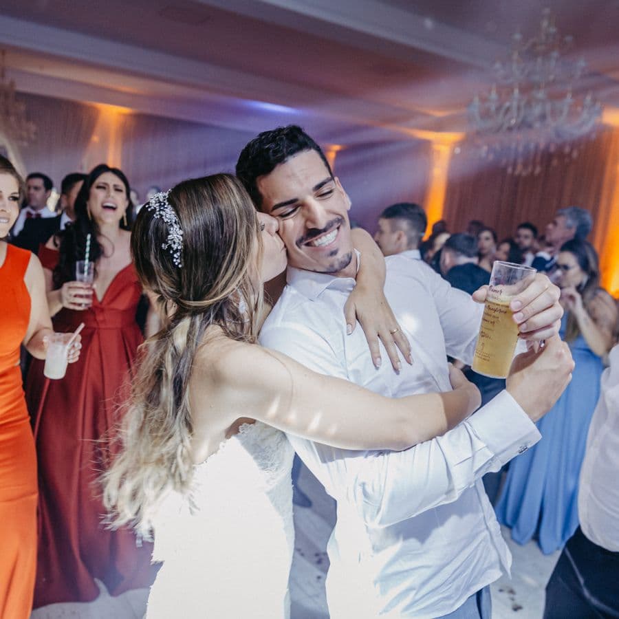 Bride kissing the groom on the cheek while guests cheer